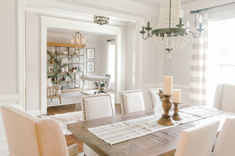dining room with wooden dining table with neutral colors and white beaded chandelier