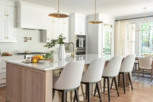 white marble kitchen counter with golden hanging lights four chairs