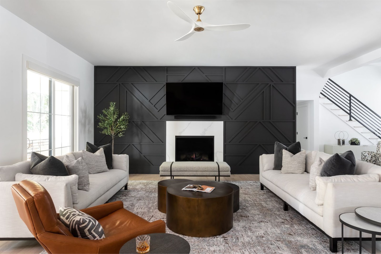 Luxury minimalist living room with leather chair and dark wood coffee table. On either side of room are twin white sofas with off-white performance fabric and dark stain legs. Z & Co. sources custom furniture in Atlanta for its clients. 