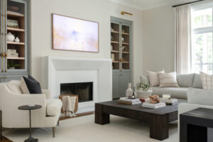 Cozy living room with square wood coffee table, blue shelves, and off-white accents.