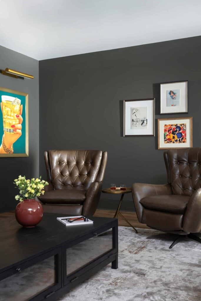 Brown leather living room chairs with speakeasy art.