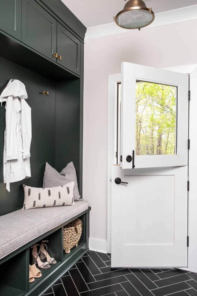 Entryway with white dutch door, green built-in storage bench, and white coat.