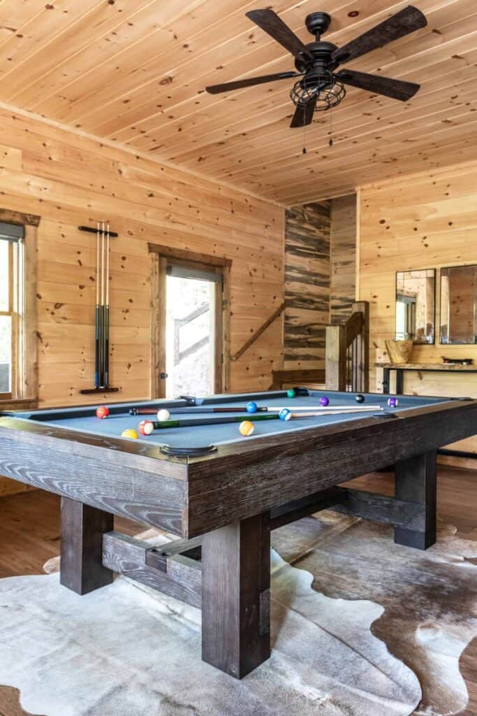 Wood pool table, hide reg, and floor to ceiling wood.