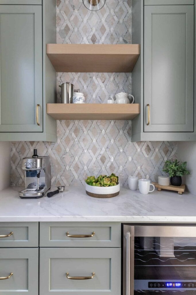 Breakfast bar with coffee machine, custom tile backsplash, and green cabinets.