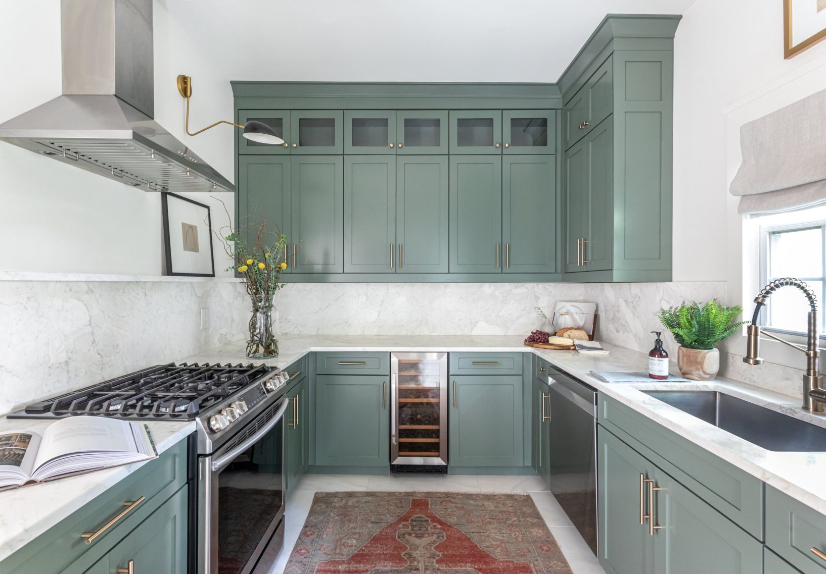 Kitchen with light green cabinets and oven range.