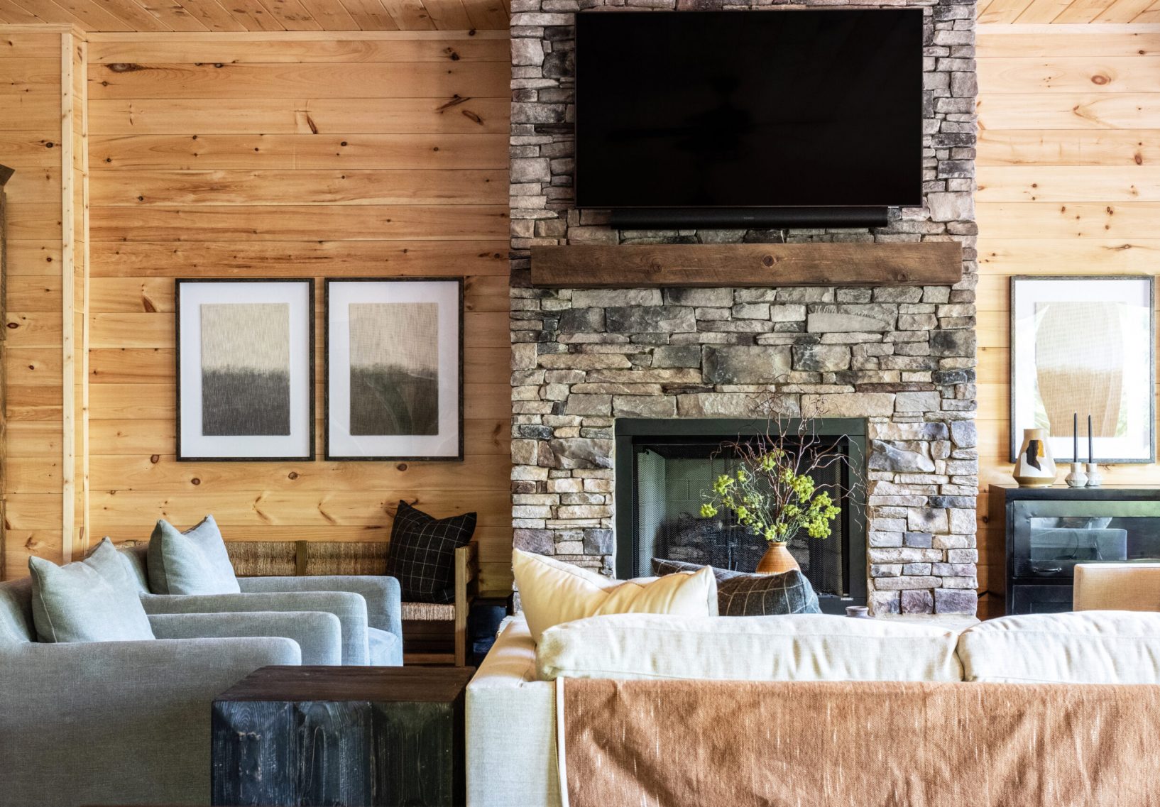 Cabin living room with stone fireplace.